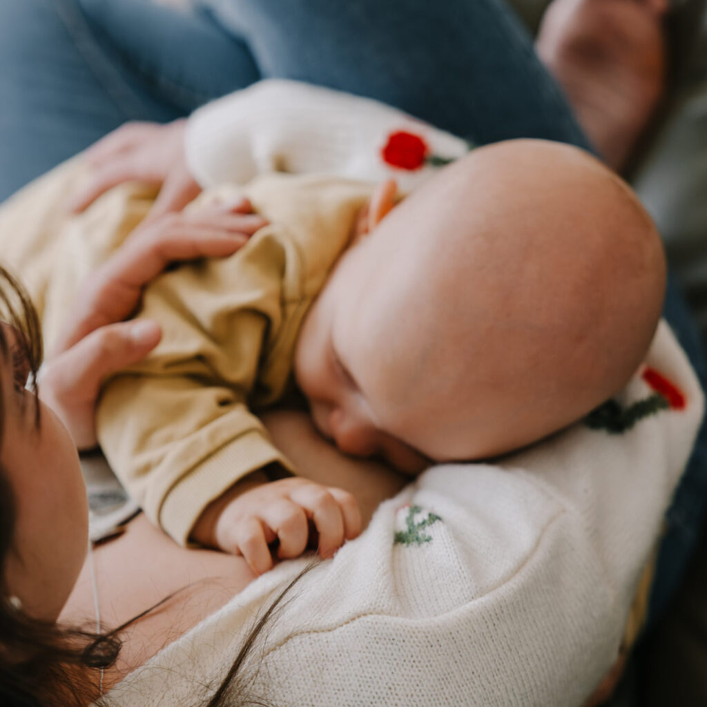 Stillendes Baby im Arm der Mutter